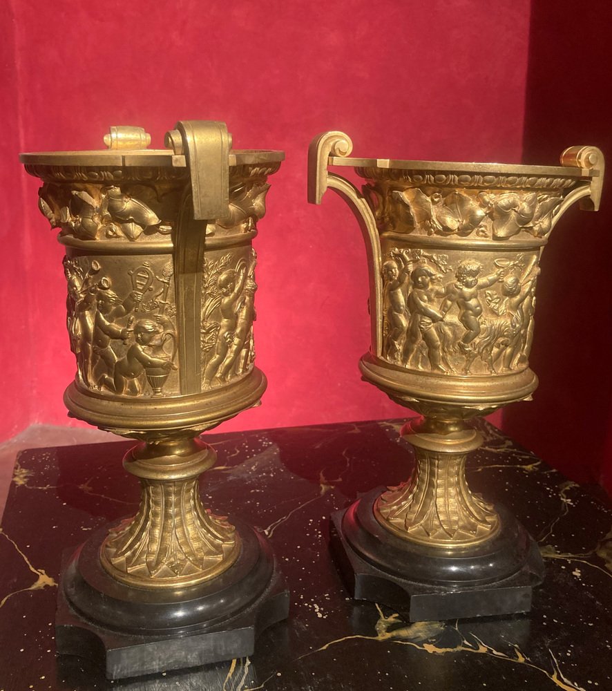 French 18th Century Louis XVI Ormolu Vases with Handles and Relief Putto on Black Belgian Marble Bases, Set of 2