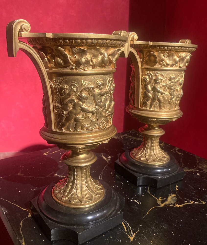 French 18th Century Louis XVI Ormolu Vases with Handles and Relief Putto on Black Belgian Marble Bases, Set of 2