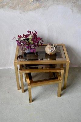 Hollywood Regency Style Nesting Tables or Flying Tables in Gold Metal and Smoked Glass, 1970s, Set of 3-AIU-2016624